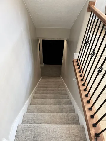Staircase featuring a textured ceiling