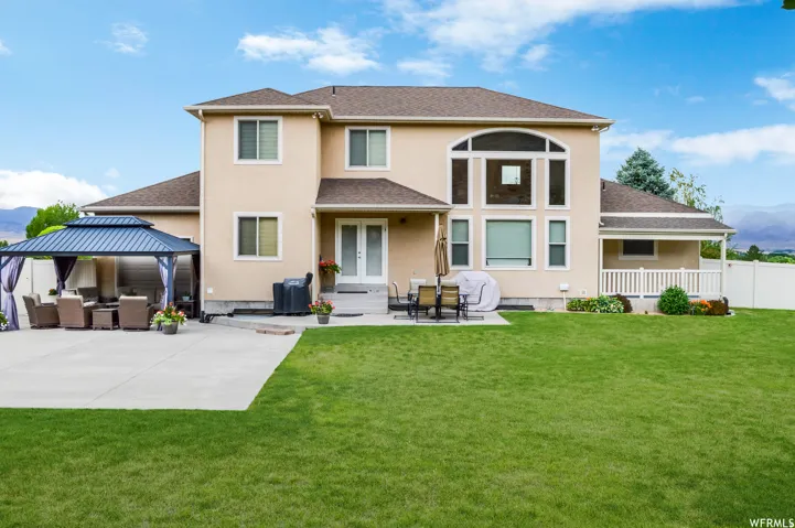 Rear view of house with a mountain view, stucco siding, french doors, and a patio area