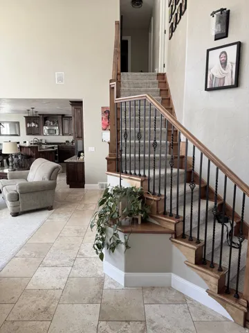 Staircase featuring a textured wall and baseboards
