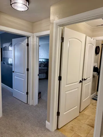 Corridor with a textured ceiling and light colored carpet