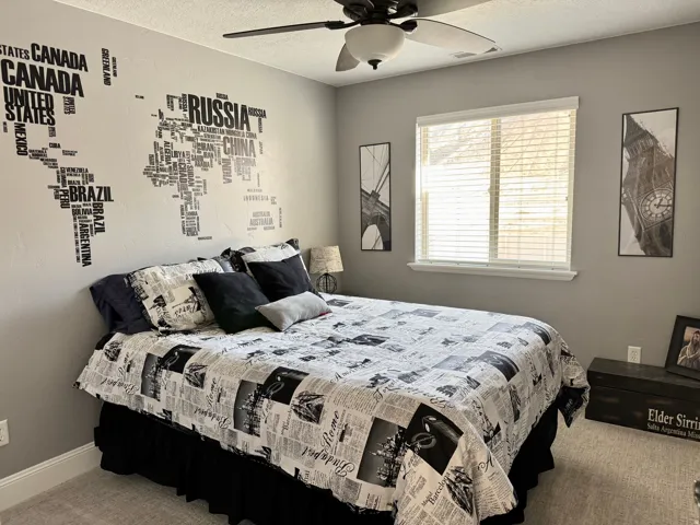 Carpeted bedroom with a textured ceiling and a ceiling fan