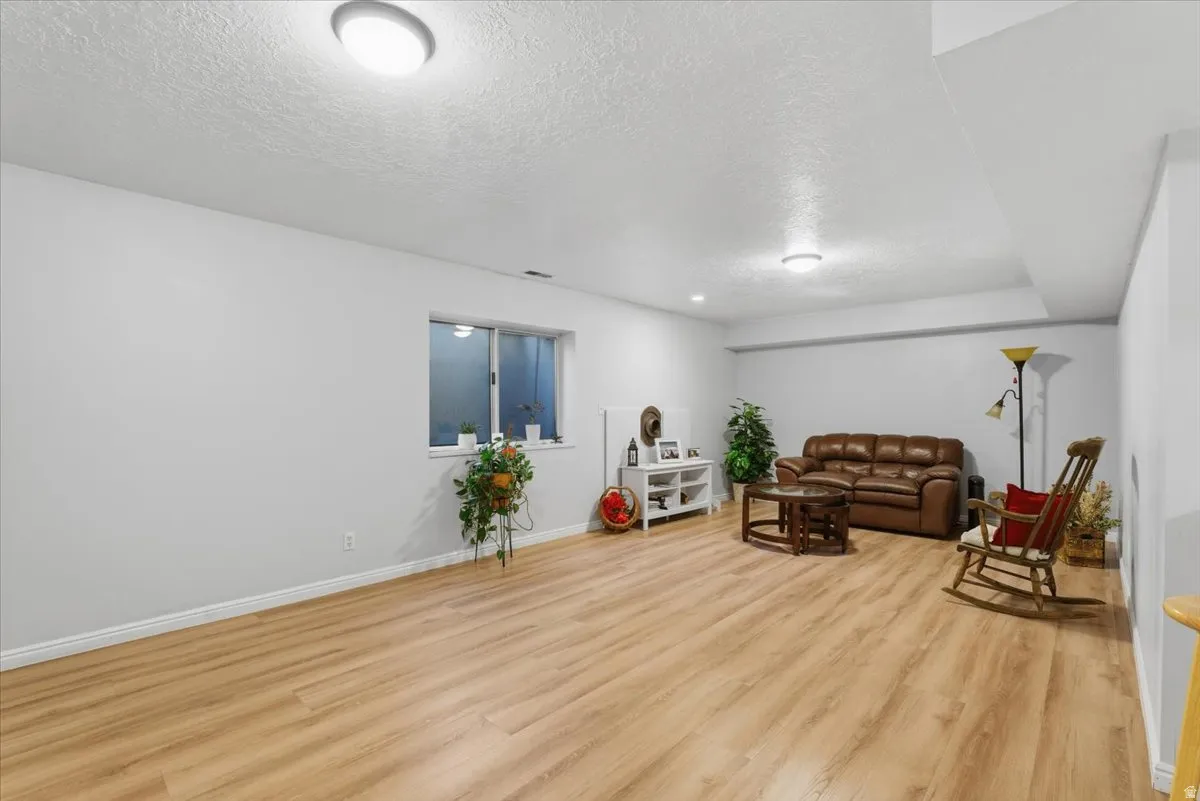 Living area with a textured ceiling and light wood-type flooring