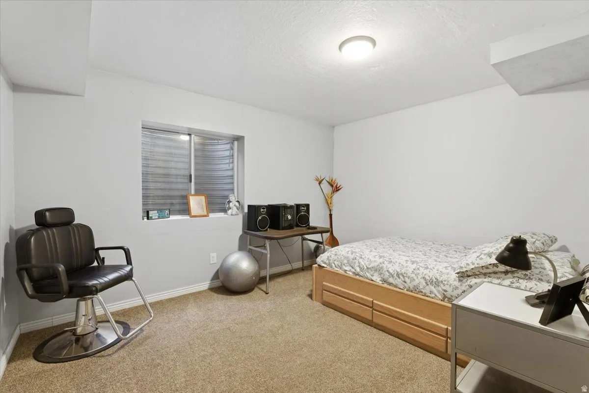Bedroom with light carpet and a textured ceiling