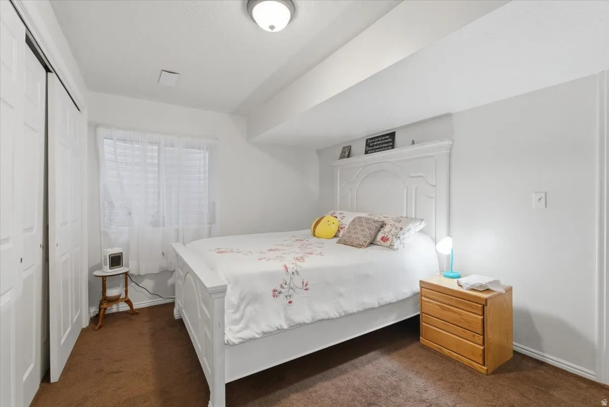 Bedroom with a closet and dark colored carpet