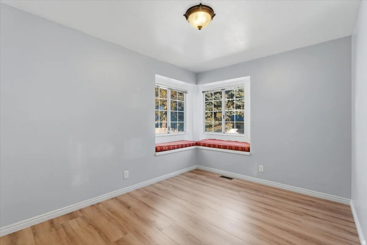 Spare room with baseboards and light wood-style flooring