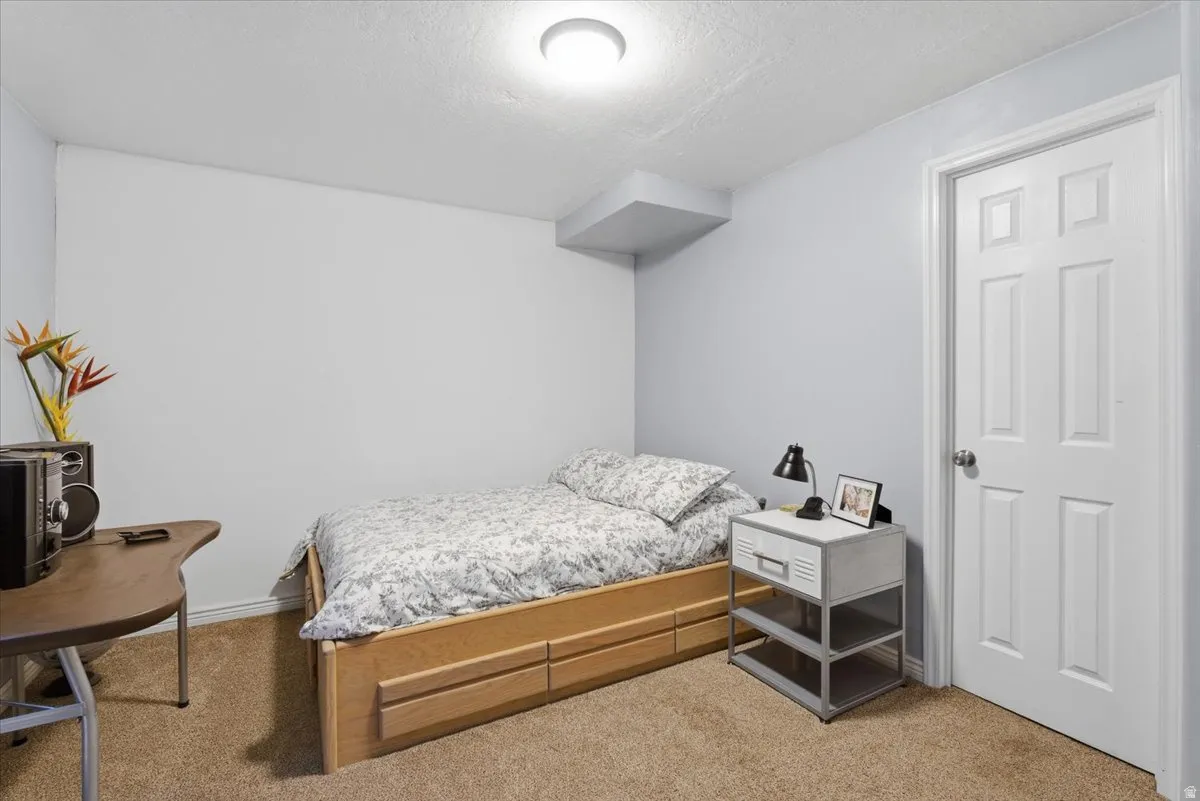 Carpeted bedroom with a textured ceiling and baseboards