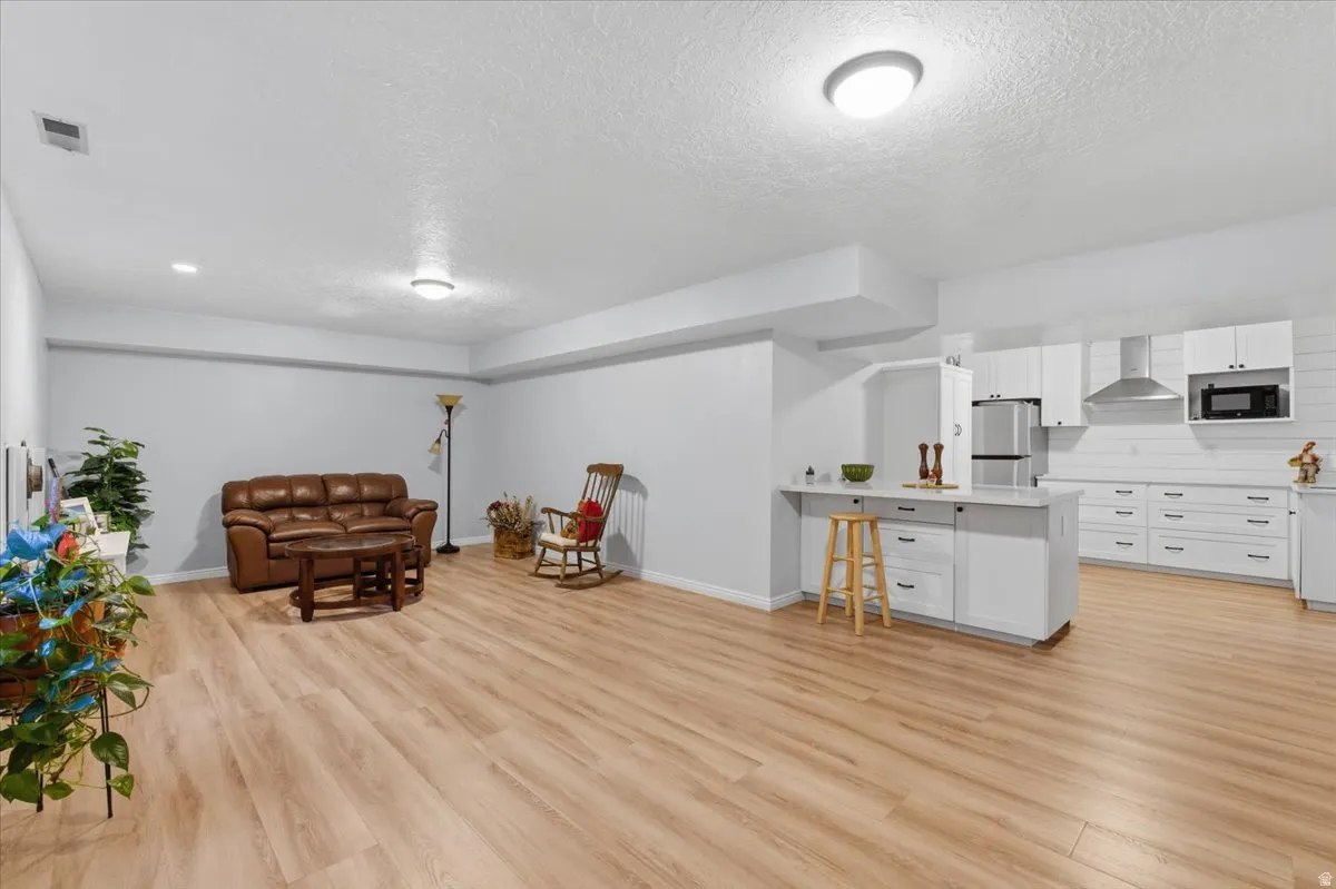 Sitting room with a textured ceiling and light wood-type flooring