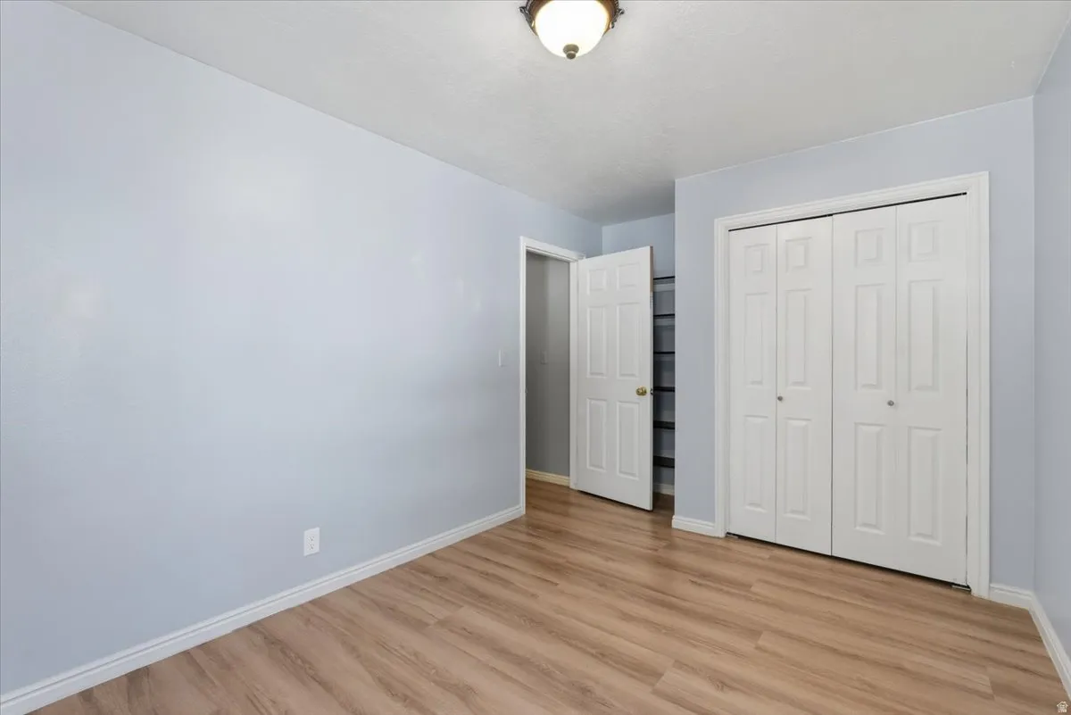 Unfurnished bedroom with light wood-style floors and a closet