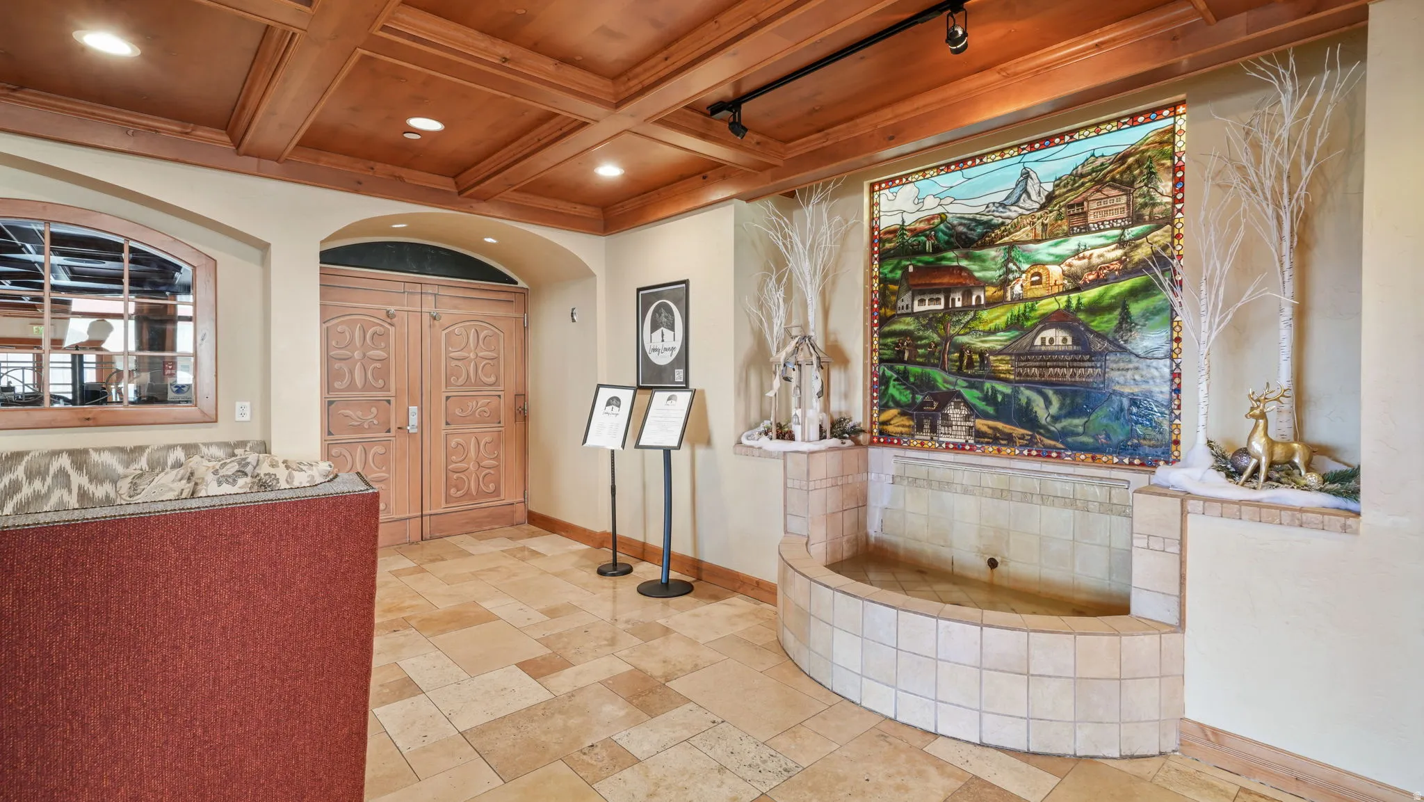 Entryway with stained glass and fountain with wood ceiling with exposed beams