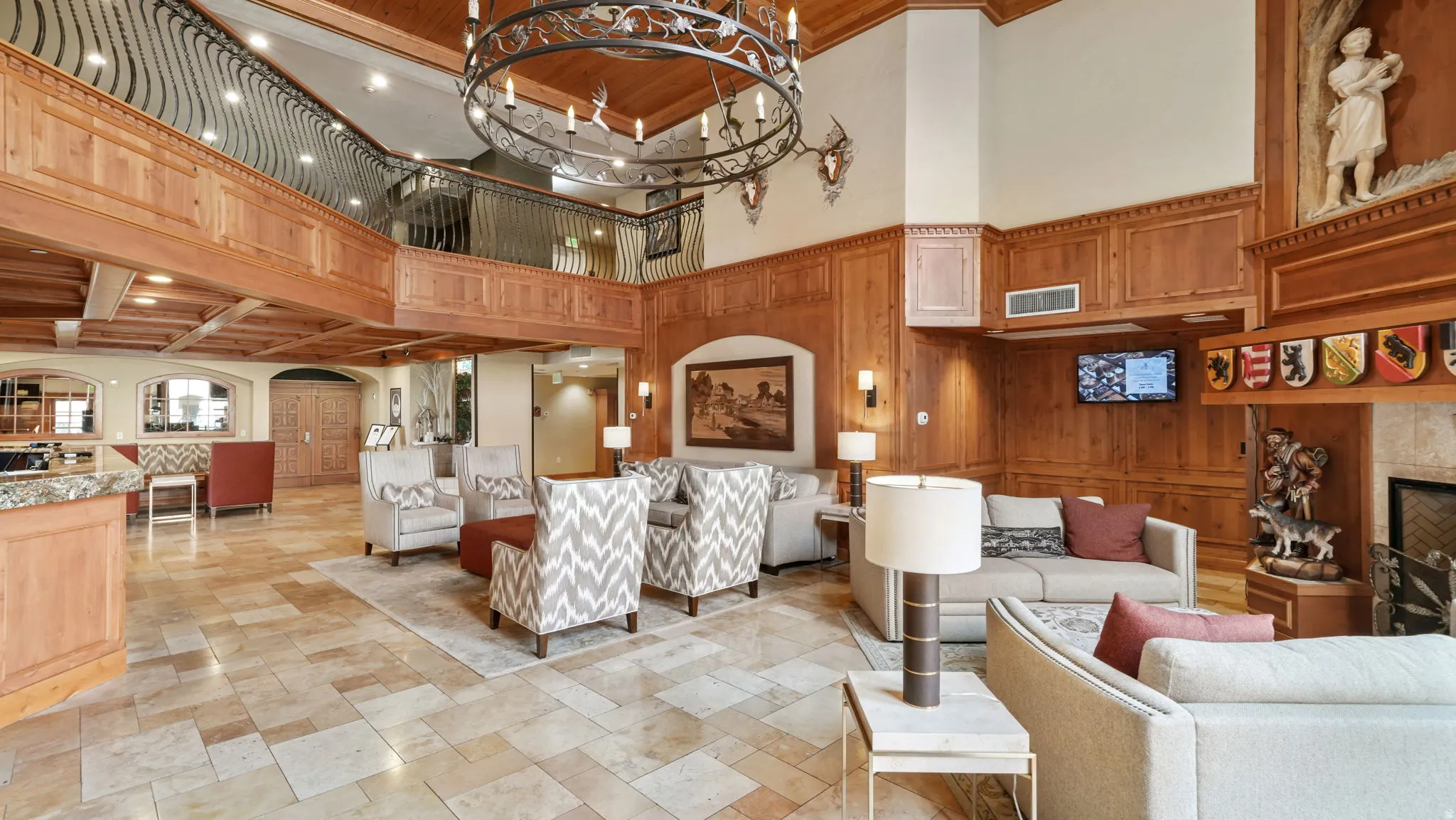 Community lobby featuring wooden walls, a high ceiling, and ornamental molding