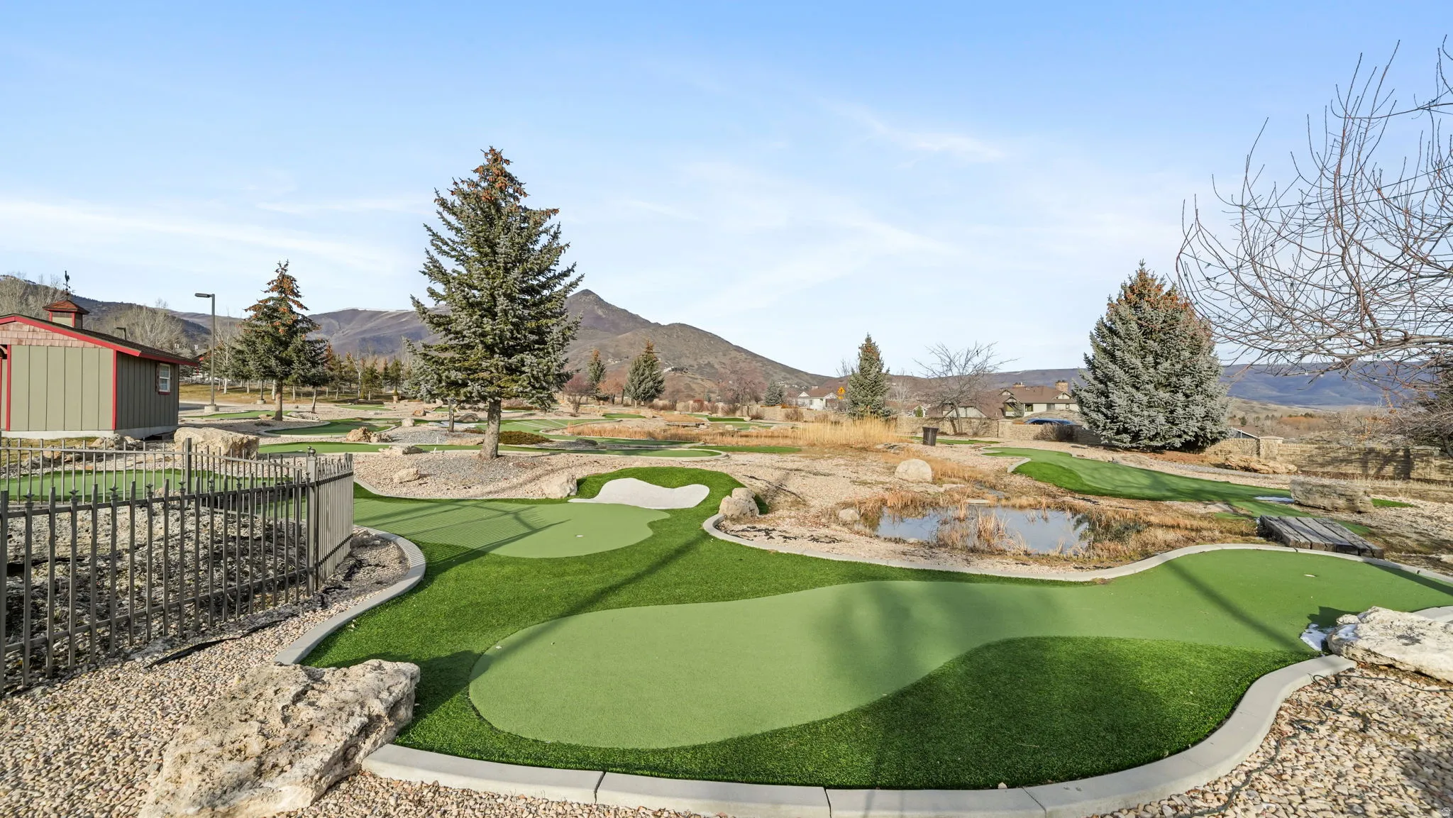 Surrounding community featuring an area to practice putting and a mountain view