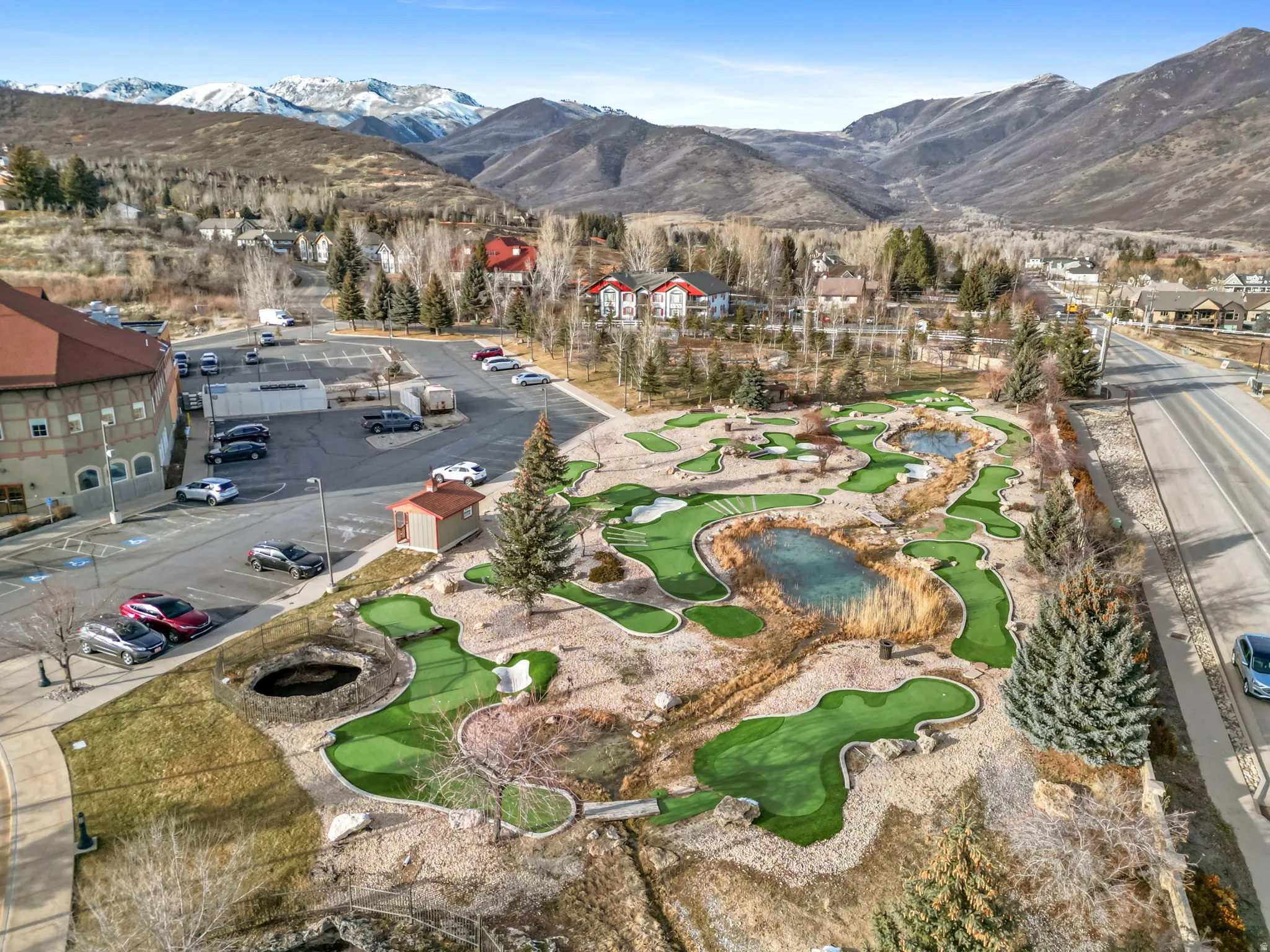 Aerial view of residential area featuring miniature golf course and mountains