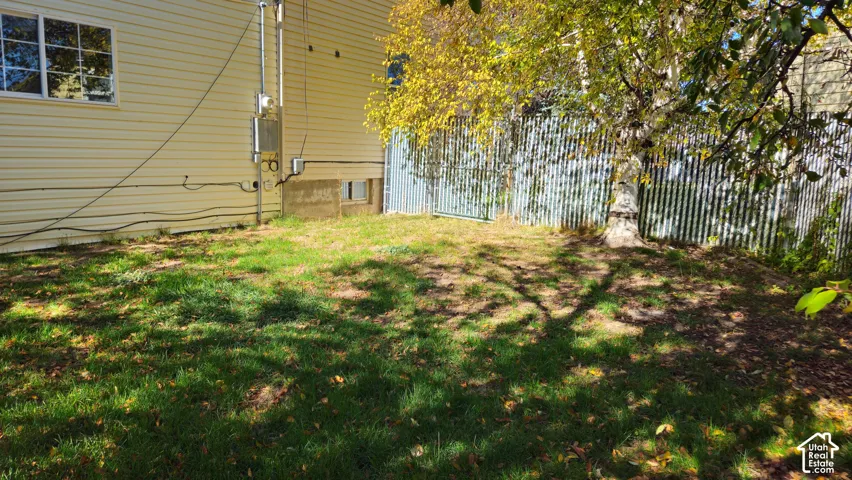Outdoor space featuring horizontal vinyl siding, a fenced perimeter, and a mature tree