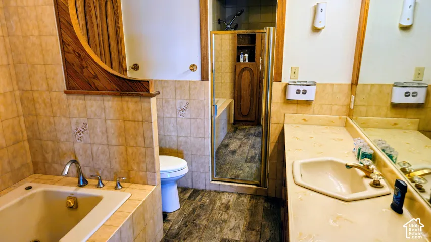 Bathroom featuring a built-in bathtub with chrome fixtures, a vanity with an integrated sink, and an enclosed shower