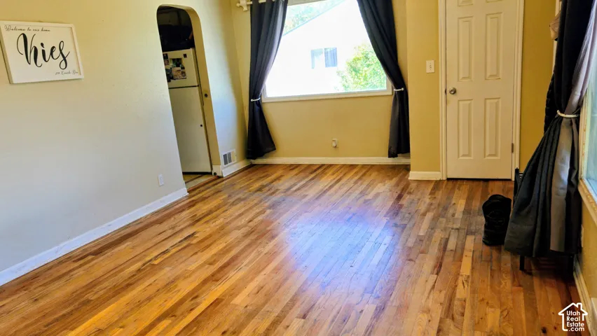 Hardwood flooring, painted walls, white trim, and a white paneled door