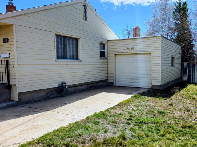 View of home's exterior with a chimney, a garage, and concrete driveway