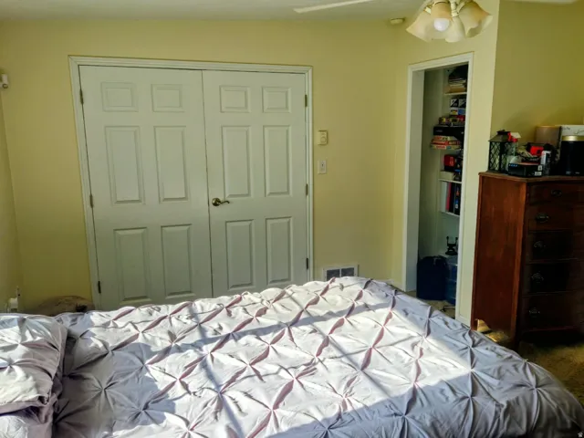 Bedroom with a closet, ceiling fan, and carpet