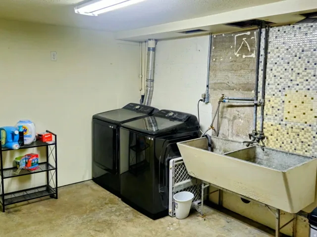Laundry room featuring concrete flooring and washing machine and clothes dryer