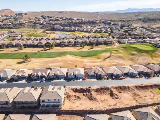 Aerial view of property and surrounding area featuring nearby suburban area