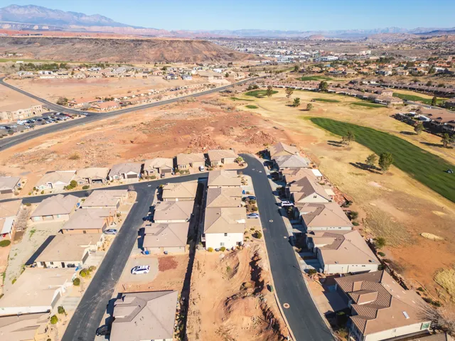 Aerial view of property's location featuring nearby suburban area, a mountainous background, and a golf course