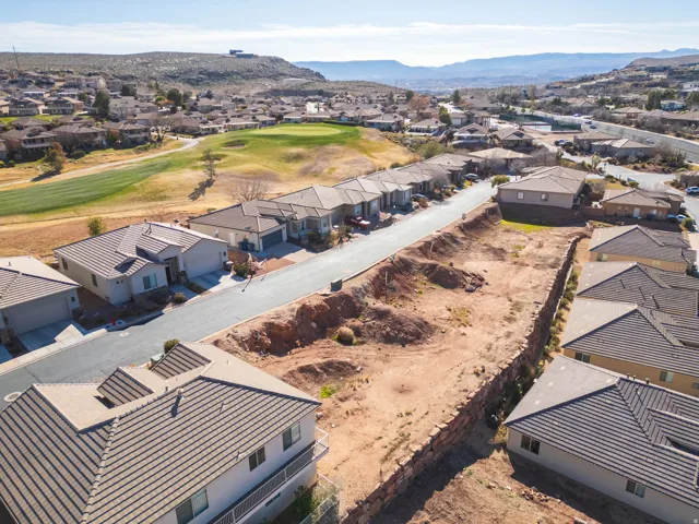 Aerial perspective of suburban area featuring mountains and a golf club