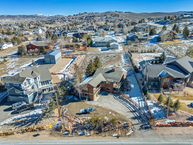Snowy aerial view featuring a mountain view and a residential view