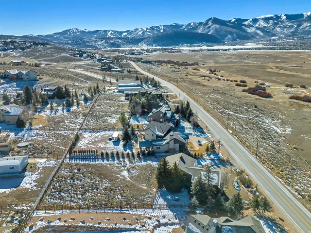 Snowy aerial view featuring a mountain view and a residential view