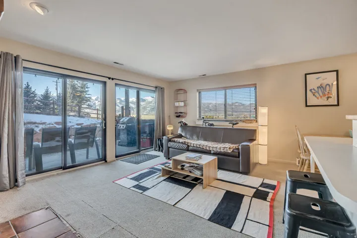 Carpeted living area featuring baseboards