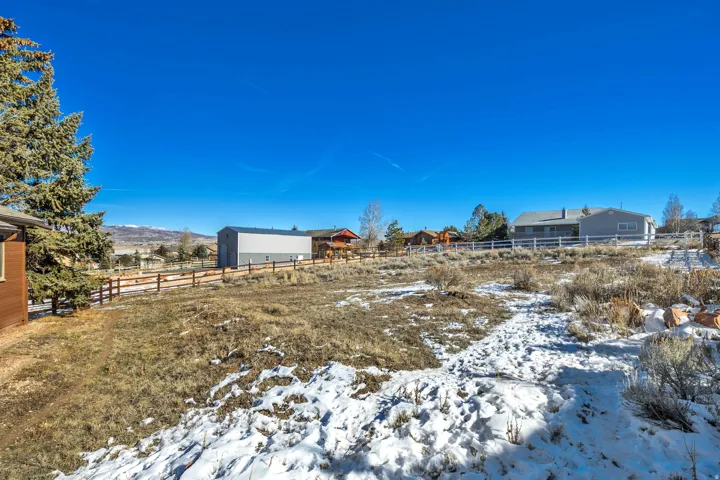 Snowy yard with an outbuilding and a pole building