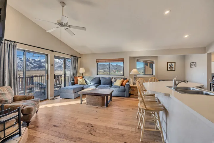 Living area featuring light wood finished floors, high vaulted ceiling, a ceiling fan, and a mountain view