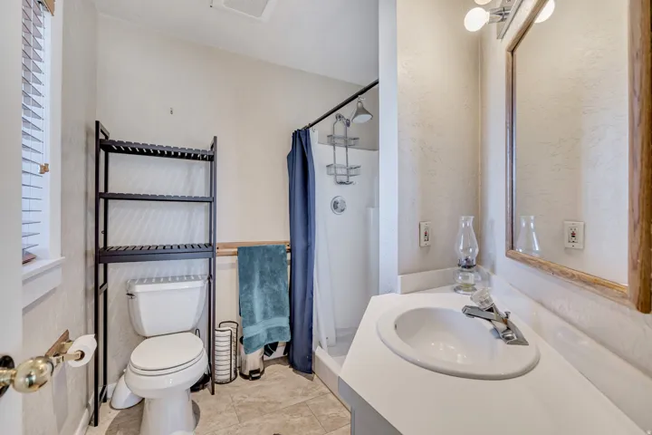 Full bath featuring a stall shower, vanity, and light tile patterned floors