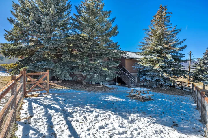 Snowy yard featuring stairway and a deck