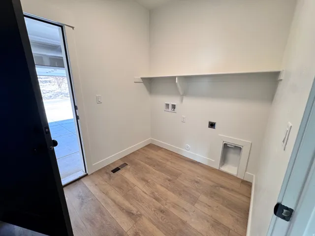 Laundry area featuring light wood-style floors, hookup for a washing machine, and electric dryer hookup
