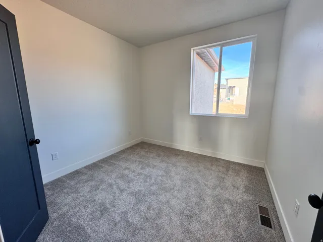 Spare room with light colored carpet and a textured ceiling