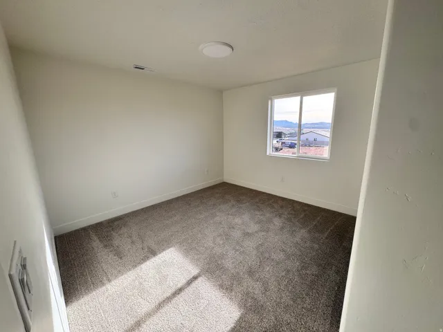 Unfurnished room featuring carpet flooring and a textured ceiling