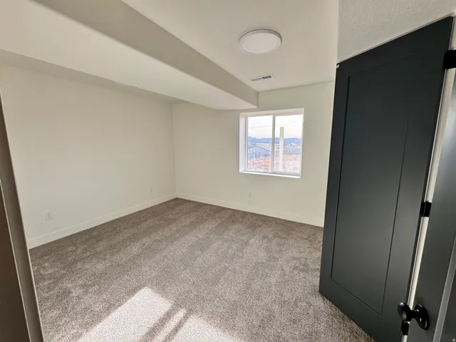 Unfurnished bedroom featuring light colored carpet and baseboards