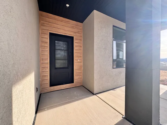 View of exterior entry with stucco siding