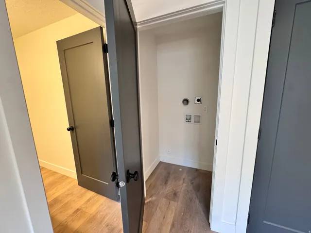 Laundry room with wood finished floors and hookup for an electric dryer