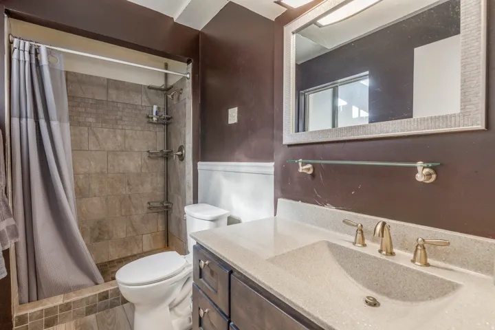 Full bath with a shower stall and vanity