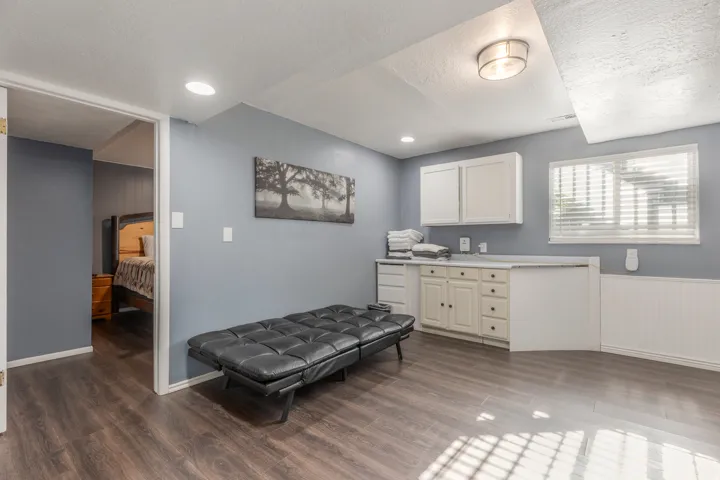 Kitchen with dark wood-style floors, a textured ceiling, light countertops, recessed lighting, and a wainscoted wall