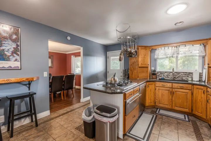 Kitchen featuring brown cabinets, a peninsula, a warming drawer, plenty of natural light, and ornamental molding