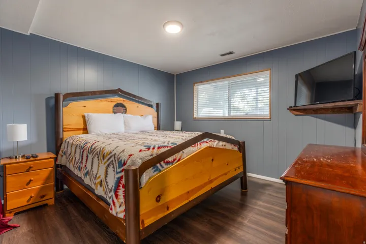 Bedroom featuring dark wood-style floors and wooden walls