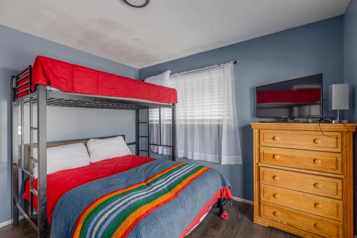 Bedroom with dark wood finished floors and baseboards