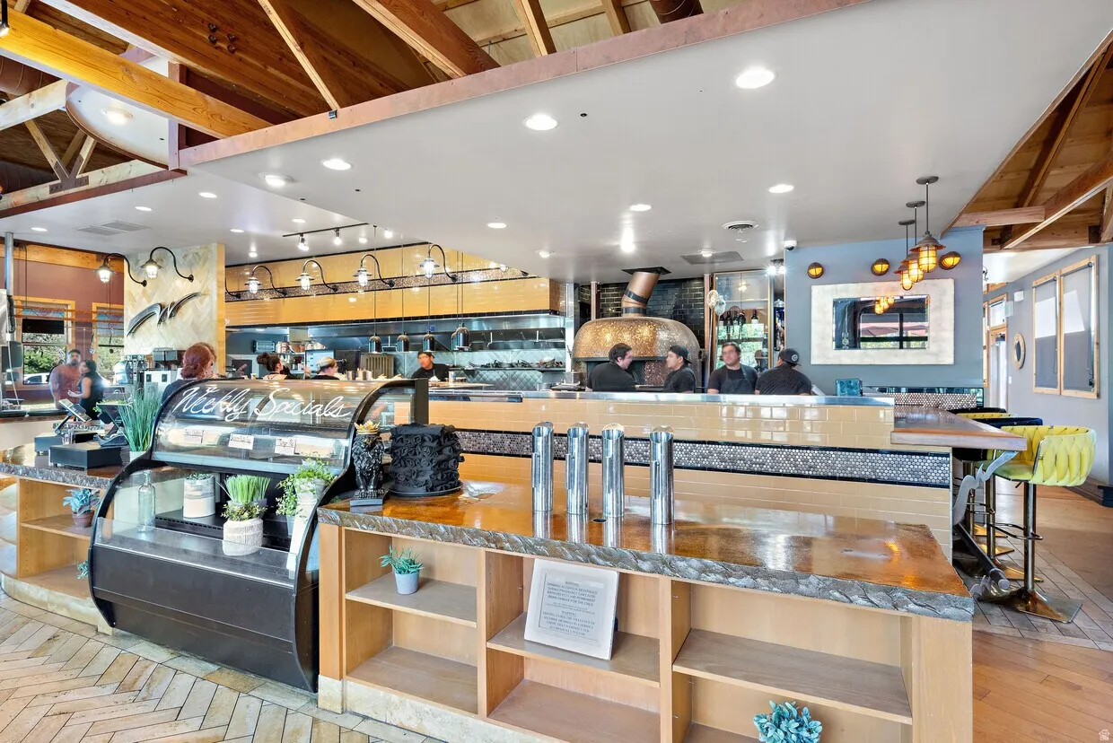 Interior space with decorative light fixtures, recessed lighting, dark stone countertops, and open shelves