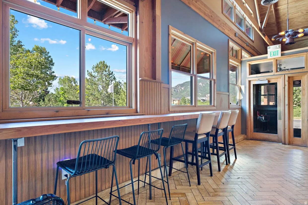 Bar area with a wainscoted wall and a chandelier