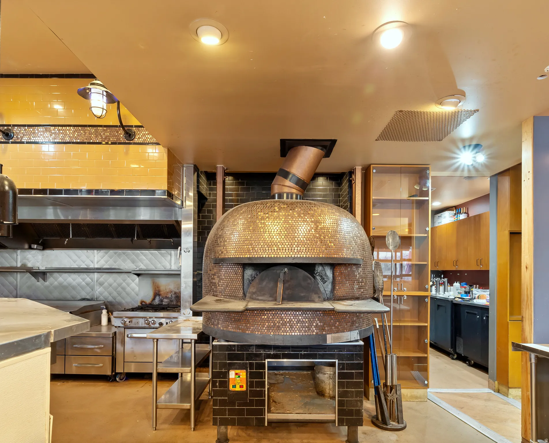 Kitchen featuring stainless steel counters, double oven range, and finished concrete flooring