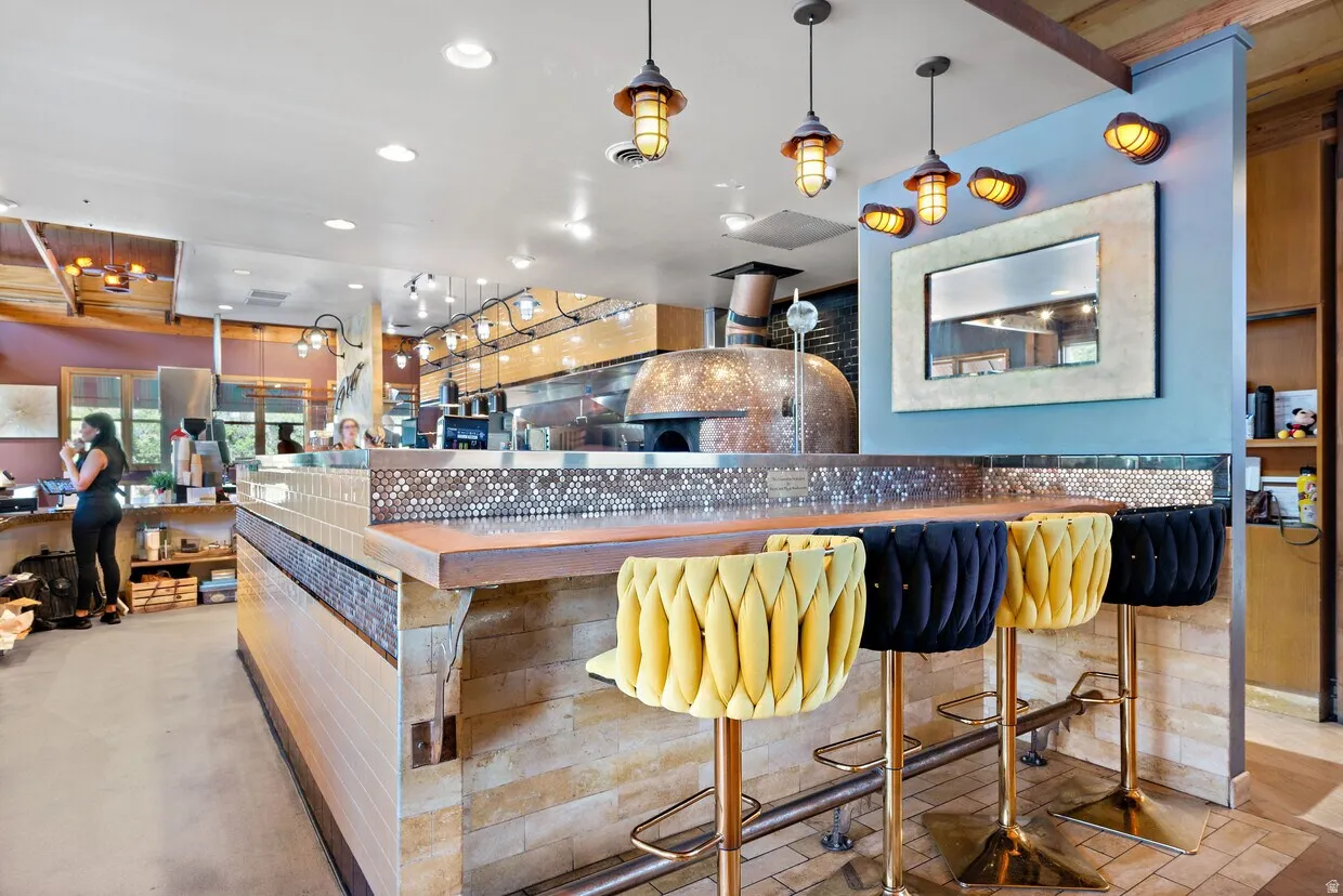Bar with butcher block countertops, hanging light fixtures, and recessed lighting