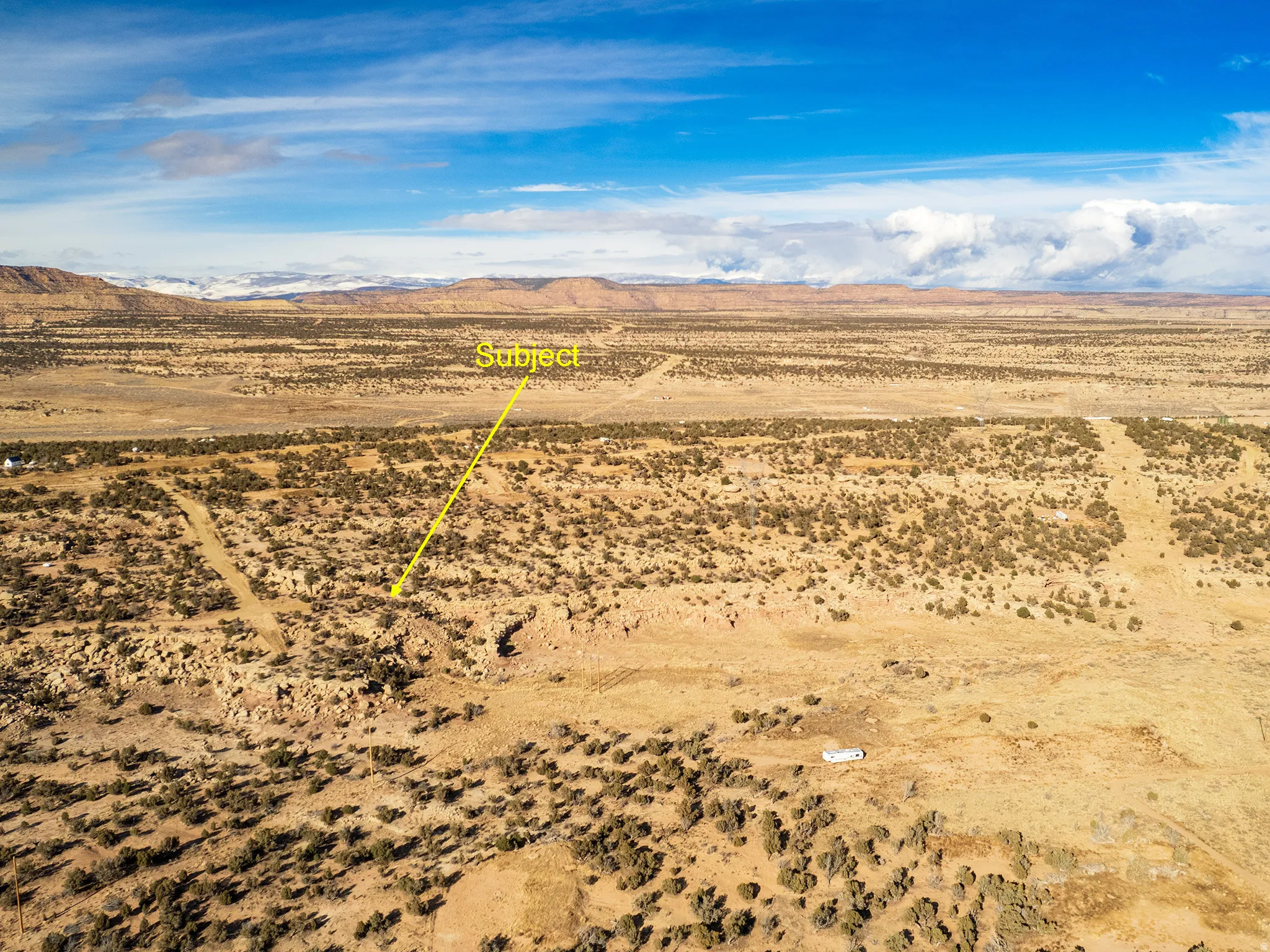 Aerial view of sparsely populated area with a mountain backdrop and a desert landscape
