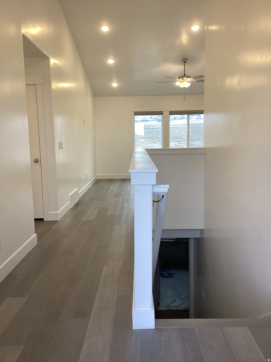 Corridor featuring dark wood finished floors, recessed lighting, and lofted ceiling