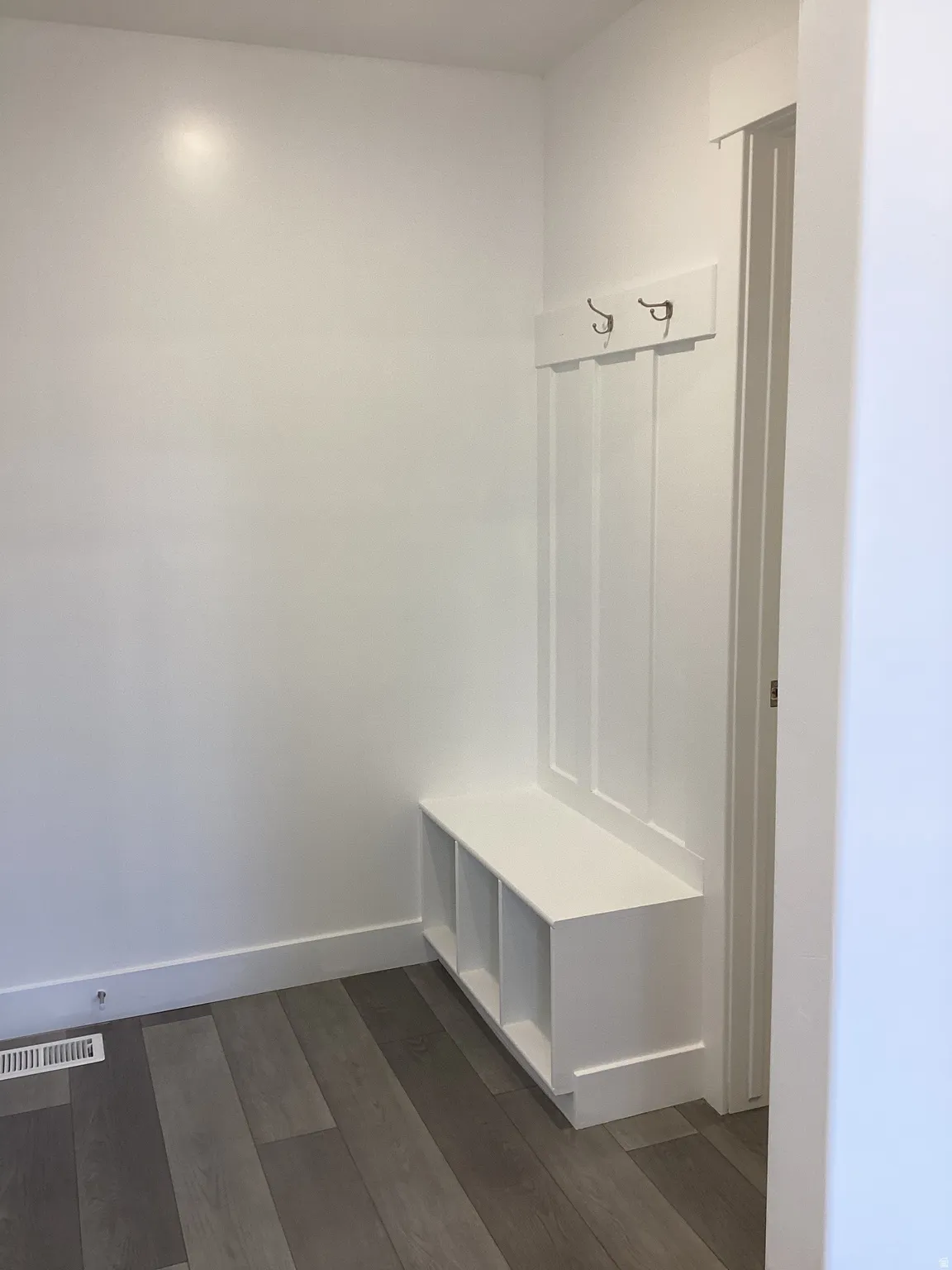 Mudroom featuring dark wood-style floors and baseboards